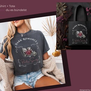 Könnte beinhalten: Dunkelgraues T-Shirt und schwarze Tragetasche mit Gothic-Motiv. Das Shirt zeigt den Text "Dark Romance" und ein Design mit Buch, Rosen und Totenkopf. Die Tragetasche hat das gleiche Design.