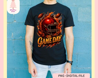 May include: Black t-shirt featuring a football helmet design with the words "Game Day" in gold. The design includes footballs and flames. The shirt is worn by a person in blue jeans.