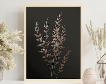 May include: A framed botanical print featuring a cluster of bronze-colored leaves against a dark background. The artwork is displayed on a white shelf, alongside decorative vases and a geometric wire house with a small vase inside. The overall aesthetic is modern and minimalist.