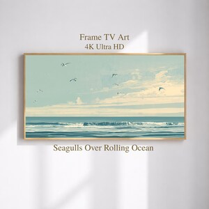 May include: A rectangular digital artwork titled Frame TV Art 4K Ultra HD, featuring a landscape painting of a rolling ocean with white-capped waves under a pale blue sky. Several seagulls are flying across the scene, labeled Seagulls Over Rolling Ocean.