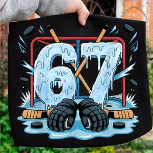 May include: Black graphic with a hockey design. The number "67" is depicted with a dripping ice effect, set against a hockey net, sticks, pucks, and gloves. The design is on a black background.