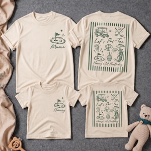 May include: Two beige t-shirts featuring dark green golf-themed graphics. The front shows a small golf hole and flag with the text Mama or Henry. The back displays a large golf collage with the text Let's Par-Tee Henry's 1st Birthday.