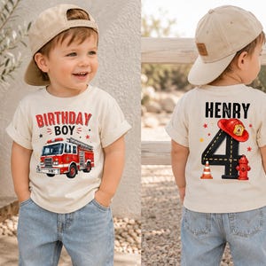 May include: A cream-colored short-sleeve t-shirt featuring a red fire truck graphic with the text "BIRTHDAY BOY" on the front and the name "HENRY" above a large number "4" with a fire helmet, hydrant, and traffic cone graphic on the back.
