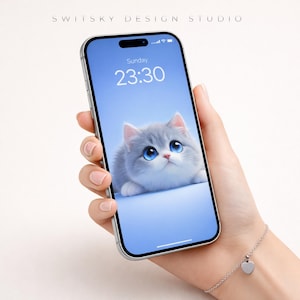 May include: A silver smartphone displaying a cute kitten wallpaper with big blue eyes. The phone is held in a hand, and a silver bracelet with a heart charm is visible. The text "Sunday 23:30" is on the screen. The words "SWITSKY DESIGN STUDIO" are at the top.