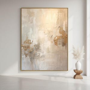 Peut inclure: Tableau mural texturé abstrait aux tons neutres de beige, crème et or, encadré d'une bordure dorée. L'œuvre présente une surface tactile en couches avec des coups de pinceau visibles, créant une esthétique moderne et élégante. La peinture est exposée dans un intérieur lumineux et minimaliste.