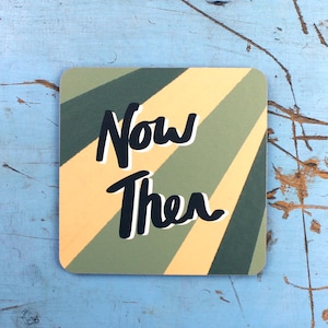 May include: A yellow and green striped coaster with the text "Now Then" written in black.