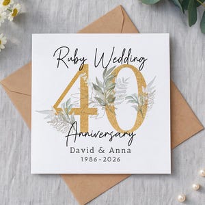 May include: A square greeting card featuring the text Ruby Wedding 40 Anniversary, David & Anna, and 1986-2026. The number 40 is printed in a large gold glitter texture, decorated with watercolour-style green botanical leaf illustrations.