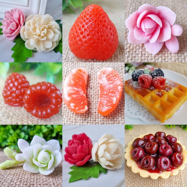 May include: A collection of handmade soaps shaped like various fruits, flowers, and a waffle. The soaps include a red strawberry, raspberries, orange slices, and a waffle topped with berries. There are also soaps shaped like pink and white flowers.