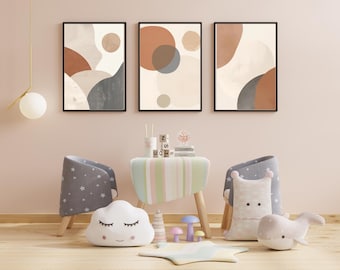 Peut inclure: Trois impressions d'art abstraites encadrées aux couleurs neutres sont suspendues au-dessus d'une petite table et de deux chaises. La pièce est décorée de jouets pour enfants, dont un coussin en forme de nuage et une chaise à motifs d'étoiles.