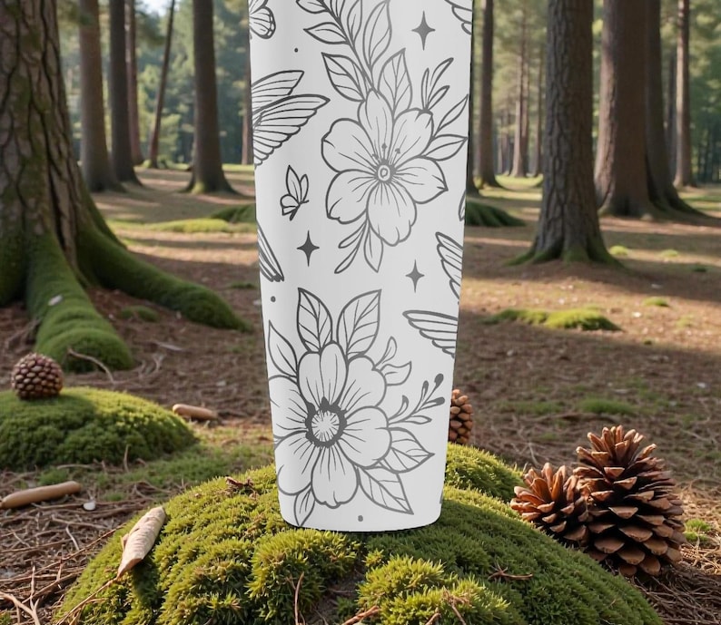 Pu&ograve; includere: Un bicchiere bianco con un motivo floreale e a farfalle grigio. Il design include fiori dettagliati, foglie, farfalle, ali e stelle. Il bicchiere cilindrico &egrave; posto su muschio in un ambiente forestale.