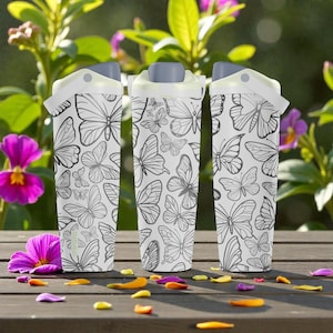 May include: Three white water bottles with a butterfly pattern. The bottles have gray lids and white handles. The background includes flowers and a wooden surface.