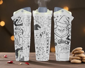 Puede incluir: Tres vasos blancos con tapas grises que presentan ilustraciones de líneas negras del Grinch, Cindy Lou Who, bastones de caramelo, árboles de Navidad y motivos festivos. Los vasos tienen una forma cónica y una tapa abatible para beber.