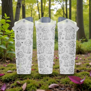 May include: Three white water bottles with grey lids and handles. Each bottle features a repeating pattern of cartoon monkeys, hearts, and stars. The bottles are on a bed of moss.