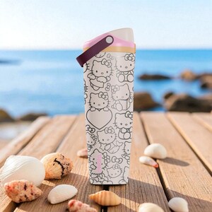 May include: A white and black Hello Kitty water bottle with a pink and burgundy handle. The bottle is covered in a repeating pattern of Hello Kitty characters and hearts. The bottle is sitting on a wooden dock with seashells.