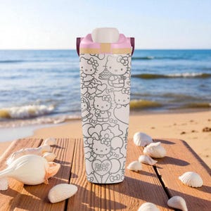 May include: A white and pink Hello Kitty water bottle with a flip-top lid. The bottle is covered in black and white illustrations of Hello Kitty characters and the words "Hello Kitty". The bottle is sitting on a wooden surface near the beach.