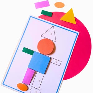 Könnte beinhalten: Ein weißes, rechteckiges Arbeitsblatt mit blauem Rand zeigt eine menschliche Figur, die aus bunten geometrischen Formen zusammengesetzt ist, darunter ein orangefarbener Kreis als Kopf, ein blaues Quadrat als Rumpf sowie Rechtecke als Gliedmaßen.