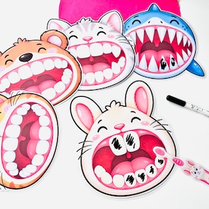 Puede incluir: Un conjunto de cinco tarjetas de actividades de higiene dental con animales: un oso, un gato, un tiburón y dos conejos con la boca abierta mostrando los dientes. Algunos dientes tienen marcas negras. Incluye un rotulador borrable y un cepillo.