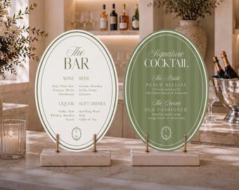 May include: Two oval-shaped bar menu signs on rectangular stone bases. The left sign is cream with green text reading The Bar, Wine, Beer, Liquor, Soft Drinks. The right sign is green with white text reading Signature Cocktail, The Bride Peach Bellini, The Groom Old Fashioned.