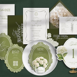 May include: A wedding stationery suite featuring olive green and white cards with floral accents. Includes a Save the Date, invitation, RSVP card with QR code, menu card, table number, and details card, all decorated with hydrangea illustrations.