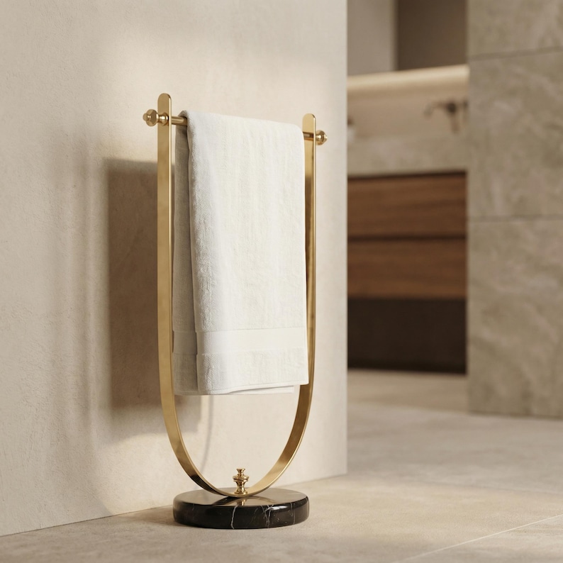 Portasciugamani in ottone lucido, base in marmo nero, accessorio moderno per il bagno. immagine 7