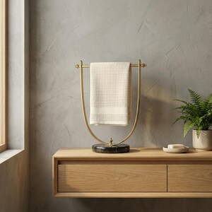 Portasciugamani in ottone lucido, base in marmo nero, accessorio moderno per il bagno. immagine 6