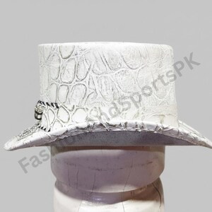 May include: White top hat with a textured, crocodile-like pattern. The hat features a black and white band around the base and a wide brim. The hat is displayed on a white form against a light gray background.