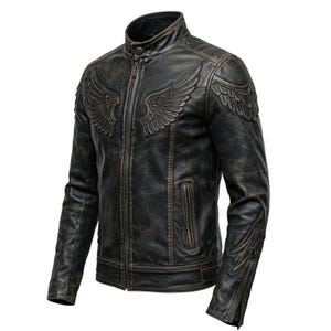 Könnte beinhalten: Eine gealterte schwarze Lederjacke mit Stehkragen und Reißverschluss. Die Jacke hat geprägte Flügeldesigns auf Brust und Schultern sowie zusätzliche Flügeldarstellungen an den Ärmeln. Die Jacke hat ein Vintage-Aussehen.