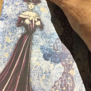 May include: A vintage-style image of a woman in a burgundy dress and a hat, with a blue and white background featuring a floral pattern and butterflies.