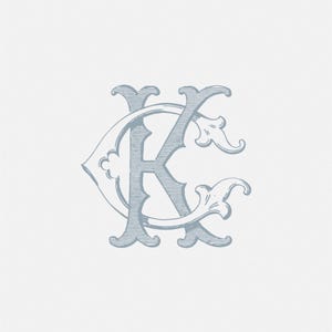 May include: A light blue monogram featuring the letters "K" and "C" intertwined. The design has an ornate, vintage style with decorative flourishes and a textured appearance, set against a white background.