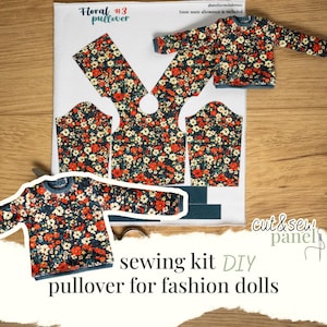 May include: A DIY sewing kit for a floral pullover for fashion dolls. The kit includes cut-out fabric pieces with a red, white, and blue floral pattern, along with a finished doll-sized sweater. The text "Floral #3 pullover" is visible.
