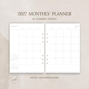 May include: A set of white A5 monthly planner inserts for 2027. The pages feature a grid layout with the text 2027 MONTHLY PLANNER and A5 PLANNER INSERTS at the top. Each page includes punch holes on the side and a calendar grid for January.