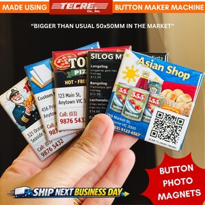 May include: A hand displays a collection of button photo magnets. The magnets feature various designs, including an Asian shop theme with canned goods and a restaurant menu. The text "BIGGER THAN USUAL 50x50mm IN THE MARKET" is visible. The magnets are approximately 5 cm x 5 cm.
