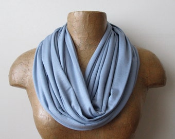 May include: A light blue infinity scarf made of soft fabric. The scarf is draped around a mannequin's neck.