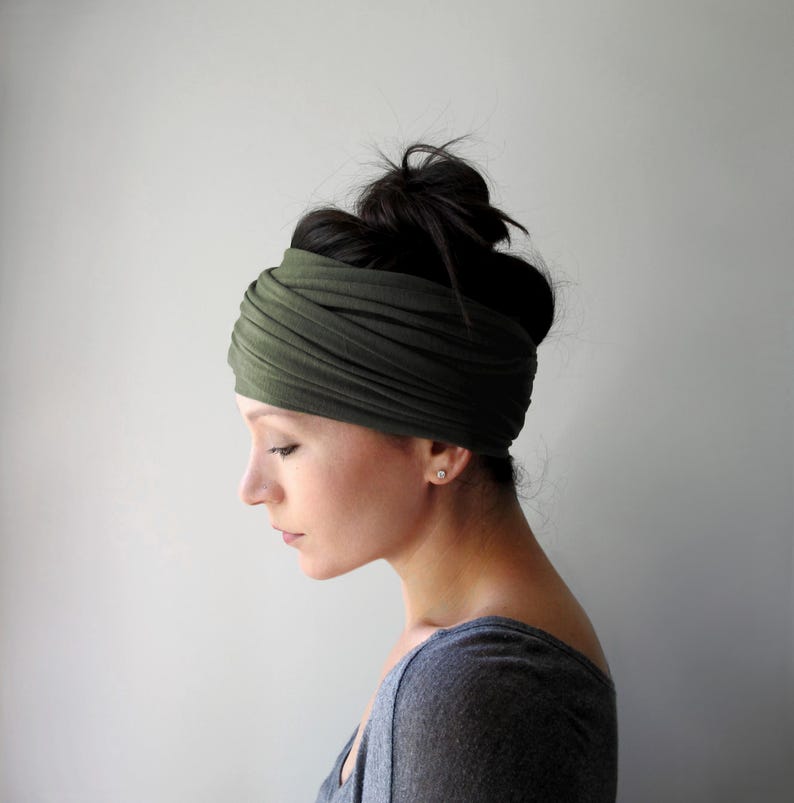 A handmade olive green head scarf made of a super soft jersey knit and is wrapped multiple times around the head.