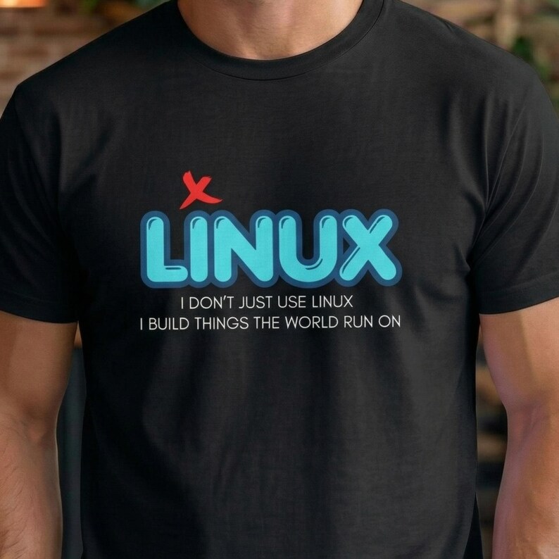 May include: Black t-shirt with the word "LINUX" in blue, outlined in a lighter blue, and a red "X" above it. Below the word "LINUX" is the text "I DON'T JUST USE LINUX I BUILD THINGS THE WORLD RUN ON."