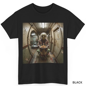 Pode incluir: Uma t-shirt preta com uma estampa gráfica de uma pessoa idosa com um cardigã estampado segurando um prato de biscoitos num corredor, ladeada por duas pequenas figuras extraterrestres verdes, com um disco voador visível ao fundo.