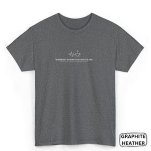 Puede incluir: Camiseta de color gris grafito jaspeado con un gráfico blanco de una taza de café y una línea de latidos. El texto dice: "WARNING: HUMAN SYSTEM FAILURE. CONTACT COFFEE IMMEDIATELY."