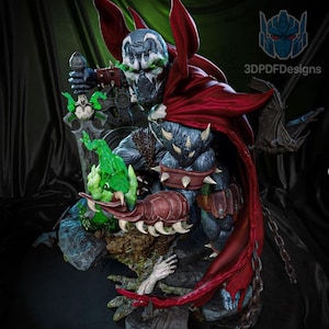 Puede incluir: Estatua detallada del personaje de cómic Spawn, con capa roja, armadura con púas y máscara con forma de calavera. La figura sostiene una energía verde brillante y una espada. La estatua está sobre una base rocosa.