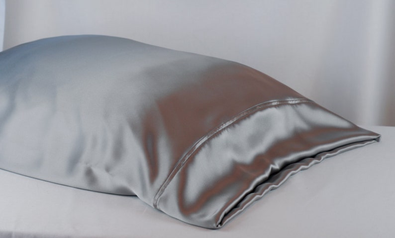 May include: A silver satin pillowcase. The pillowcase is smooth and wrinkle-free.