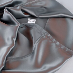 May include: A silver satin pillowcase with a white label that says "remarkable".
