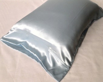 Könnte beinhalten: Ein hellblauer Kissenbezug aus Satin. Der Kissenbezug ist glatt und seidig.