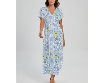 May include: A floor-length, V-neck dress with short sleeves. The dress features a blue and white tile pattern with yellow lemon accents. The dress is worn by a person wearing white sandals.