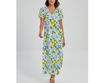 May include: A V-neck maxi dress with a vibrant lemon and floral pattern. The dress features short sleeves and a flowing skirt. The design incorporates yellow lemons and blue floral elements on a white background, creating a summery aesthetic.