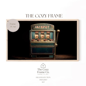 May include: A framed print featuring a vintage slot machine with the word "JACKPOT" at the top. The machine is teal and gold, set against a dark background. The frame is light-colored, and the print is labeled "Frame TV Art."
