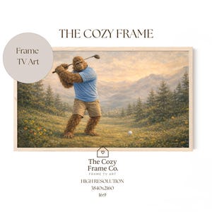 Puede incluir: Una impresión enmarcada que presenta a un Sasquatch jugando al golf en un campo verde con montañas al fondo. El Sasquatch lleva una camisa azul y pantalones cortos color caqui. El texto "THE COZY FRAME" está en la parte superior. The Cozy Frame Co. está en la parte inferior.