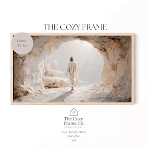 Puede incluir: Una impresión enmarcada de una escena religiosa. La obra de arte representa una figura con túnicas blancas saliendo de una cueva hacia una luz brillante. El marco es de madera de color claro. El texto en la imagen dice "THE COZY FRAME" y "The Cozy Frame Co."