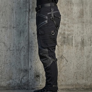 May include: Black tactical cargo pants featuring multiple zippered pockets, a large side pocket with a MOLLE-style webbing grid, adjustable straps with metal D-rings, reinforced knee panels, and a belt with a buckle closure at the waist.