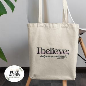 Può includere: Una borsa tote in tela beige con il testo stampato in nero I believe; help my unbelief. Mark 9:24. La borsa ha due lunghi manici a spalla e un corpo rettangolare. Un piccolo logo circolare con il testo share PURE WORDS è visibile.