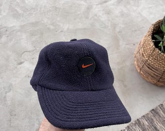 Gorra Nike azul marino de forro polar vintage de los años 90 con orejeras, estilo Y2K, estilo minimalista y poco común para exteriores.