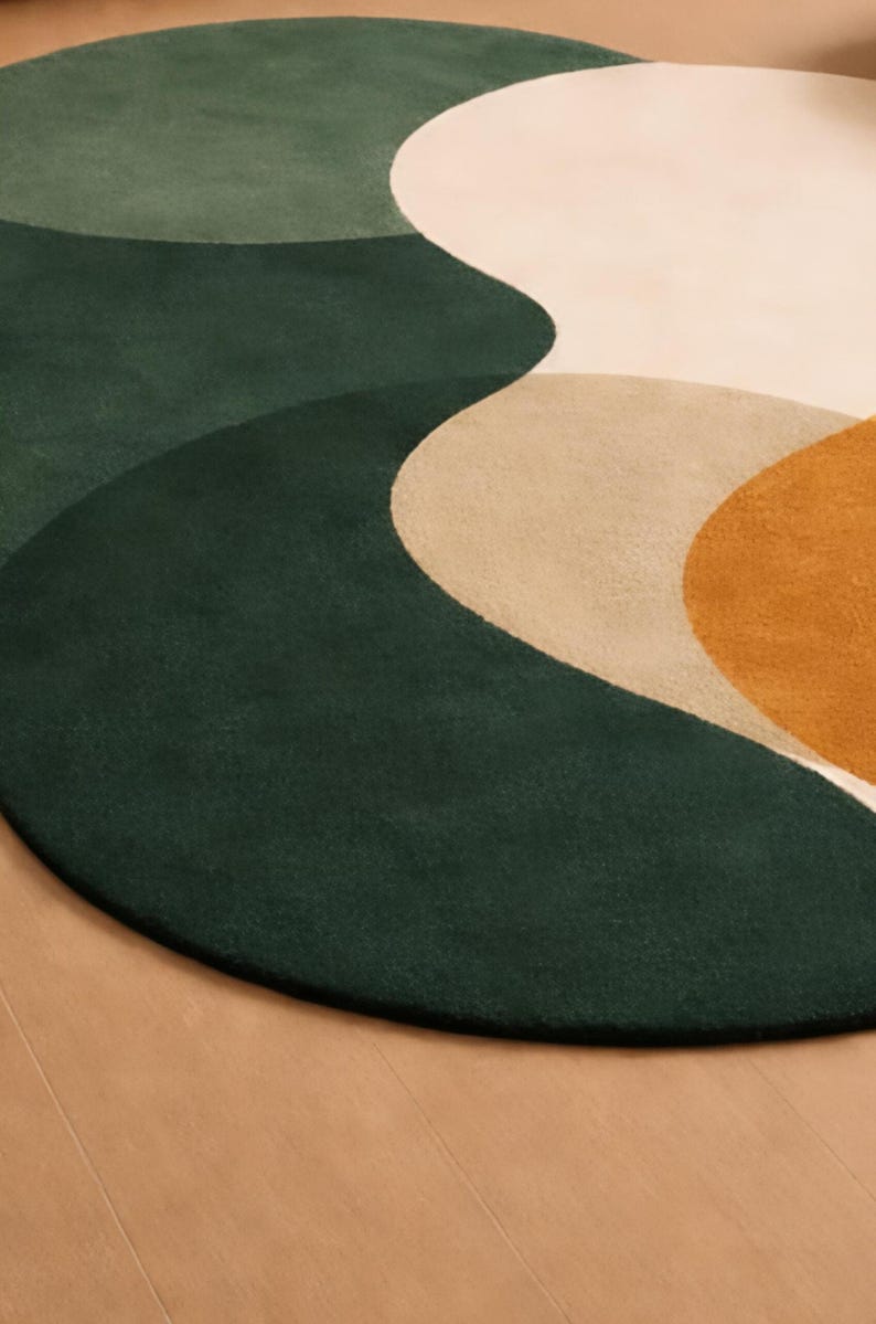 May include: A round rug with a modern design. The rug features a combination of colors, including dark green, light green, beige, and mustard yellow. The design has a flowing, abstract pattern.